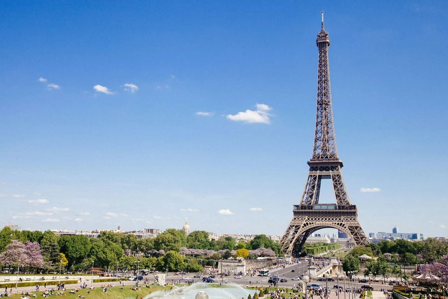 Eiffel Tower and green gardens beneath a blue Paris sky